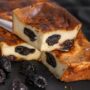 Prăjitura Far Breton porționată pe o spatulă, alături de prune uscate