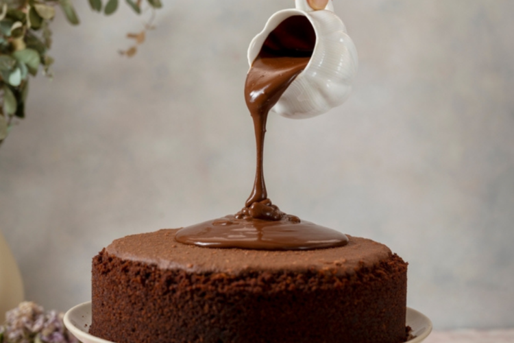 Glazura de ciocolată turnată peste un blat de tort