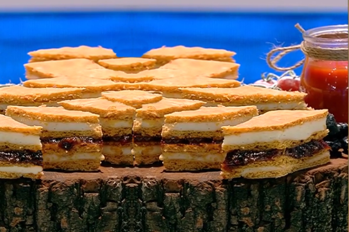 Porții de prăjitură cu suc de roșii în aluat pe un suport de lemn