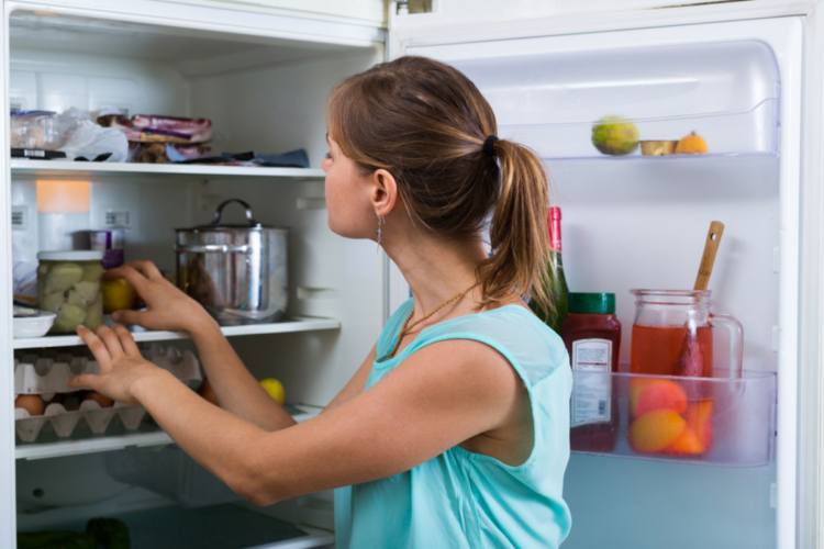 O femeie care face curățenie în frigider