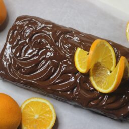Prăjitură glazurată cu ciocolată și decorată cu felii de mandarine