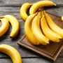 Cum se păstrează bananele ilustrat cu ajutorul mai multor banane pe un blat de lemn