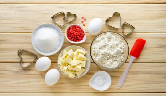 Ingrediente pentru biscuiți cu glazură albă și inimioare roșii