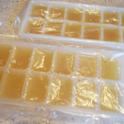 Cuburi din supă concentrată de pui în forme pentru congelator, acoperite cu folie