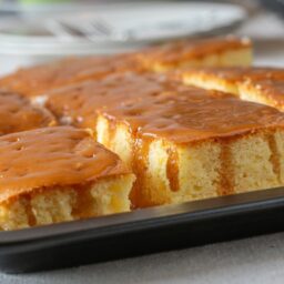 Prăjitură cu găuri și sos caramel – Poke Cake, porționată în tavă