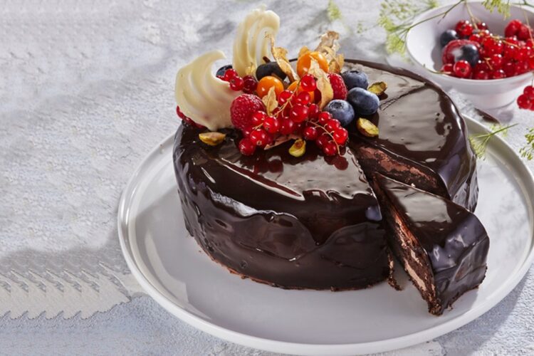 Tort de ciocolată cu glazură oglindă porționat pe platou